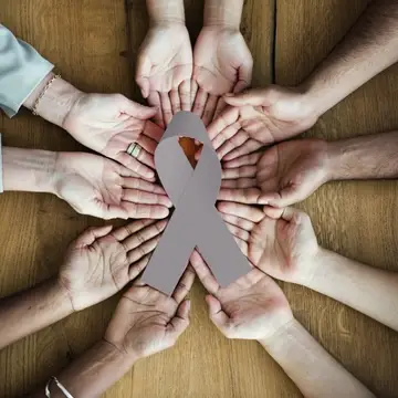 Hands holding a gray ribbon