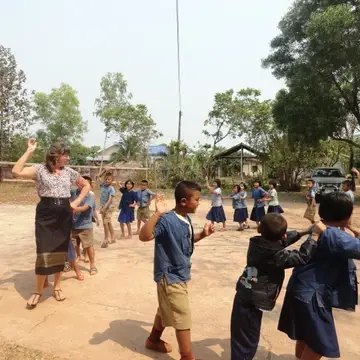 teacher leads the class walking in a circle while dancing