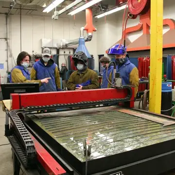 welding students use a plasma cutter