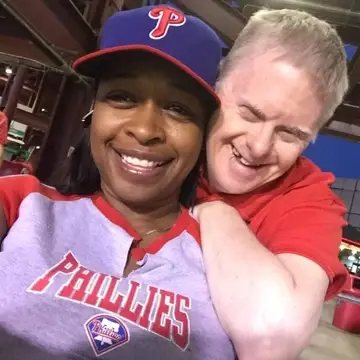 A male and female smile into the camera at a baseball game