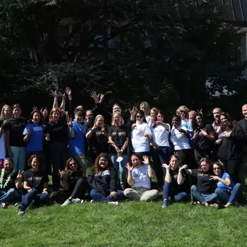 A group photo of about 40 people, taken outdoors. Most people wear a shirt that reads "LiveUnited".