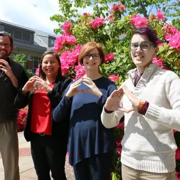 a row of four people with the hands in the shape of "o"s