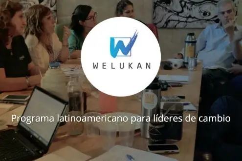 Personas en reunión de trabajo y el logo de Welukan