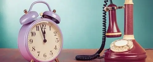 An antique telephone and an alarm clock.