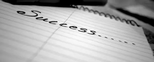 A close up of the word success written on a notepad.