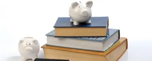 A piggy bank on top of a stack of books.
