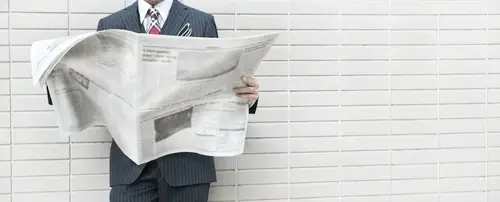 A person reading a newspaper.