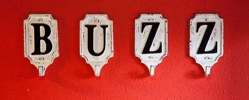 The word "Buzz", with each letter on a different coat hook.