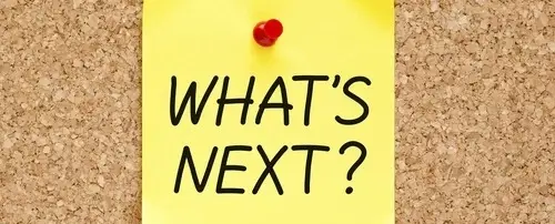 A yellow note that says' What's Next?' pinned to a board.