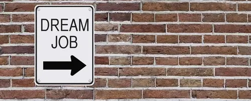 A wall with  the sign 'Dream Job' pointing to the right.