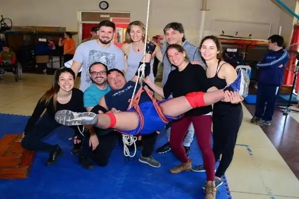 Taller de Danza Aérea inclusiva con Yanina Corigliano y varios colegas sosteniendo a una chica participante