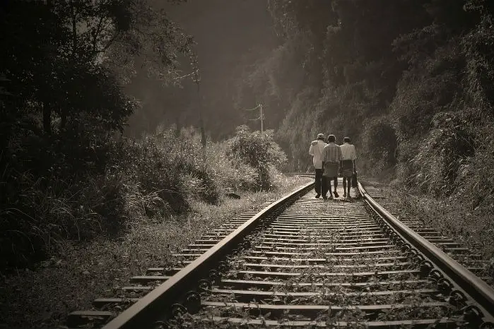 Personas caminando por una vía de tren