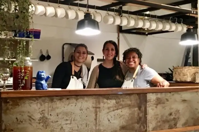 Tres mujeres sonriendo en la barra del restaurante