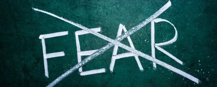 A chalkboard with the word 'Fear' crossed out.