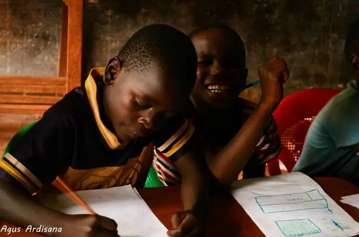 Niños en una escuela escribiendo