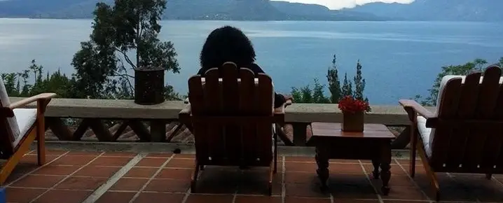 Someone sitting on a chair overlooking the water.