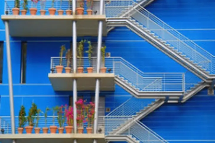 Unas escaleras externas con varias flores en cada piso