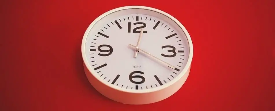 Relógio branco com fundo vermelho.