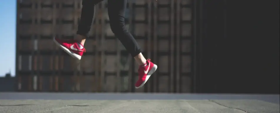A person jumping. They are wearing red sneakers.