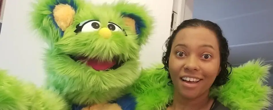 Sarah McKenzie poses with Ida the green puppet.