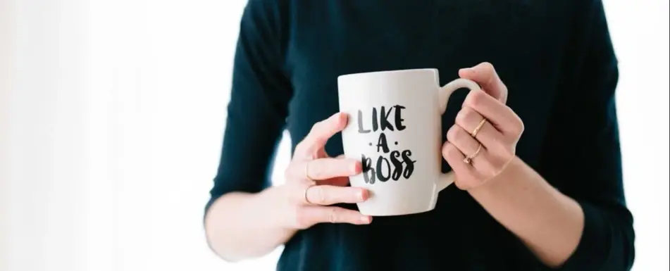 Someone holding a mug that says 'Live A Boss'
