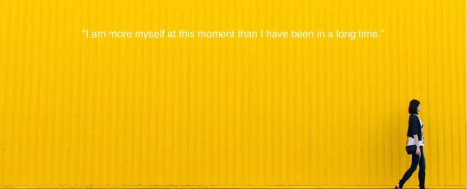 A quote with a picture of a woman walking by a yellow wall.