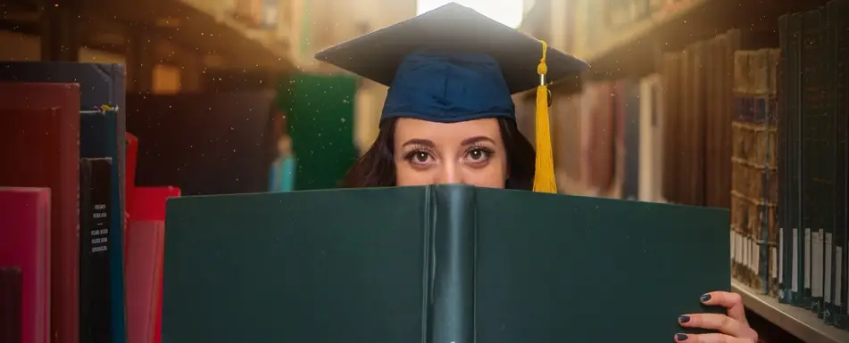 Woman in graduation cap holding book