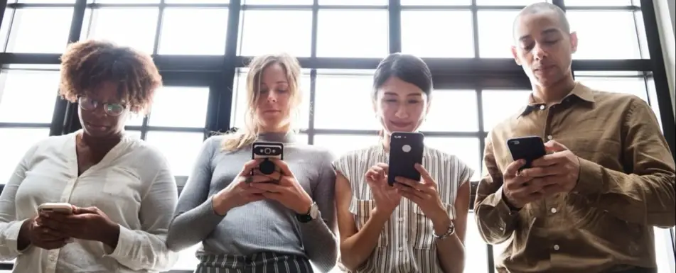 A group of people looking at their phones.