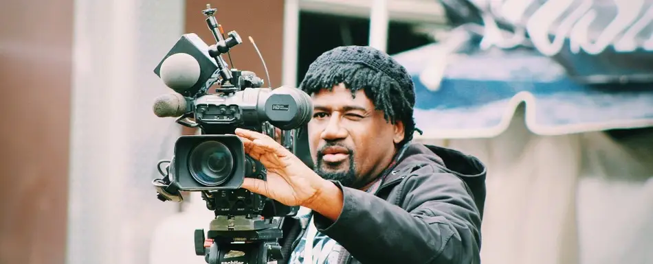 A man adjusts a professional film camera.