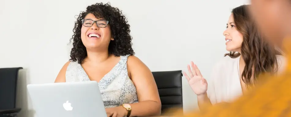 women in an office laughing