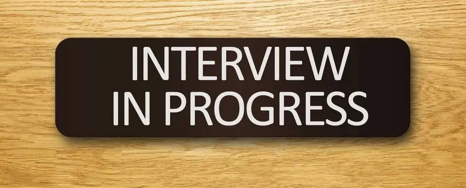 A door plaque that says, "Interview in progress."