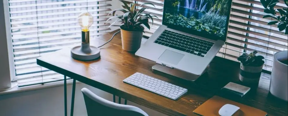 A work desk with a laptop and keyboard.