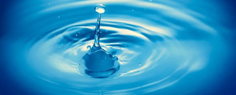 A drop of water dropping into a larger body of water.