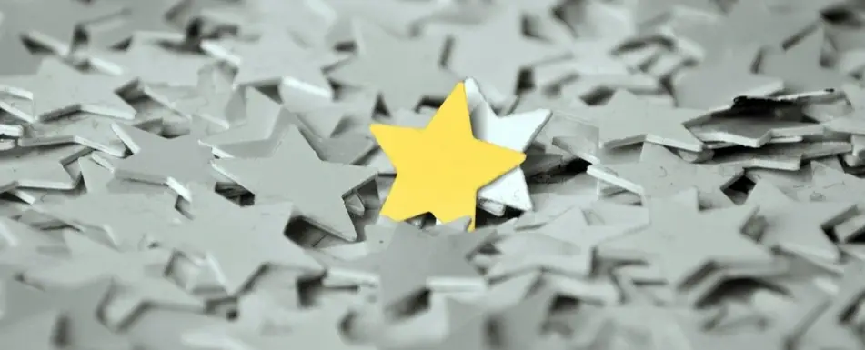 A pile of paper stars with one yellow star in the middle.