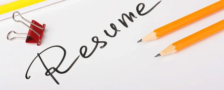 A piece of paper that says, "Resume" in cursive on it.
