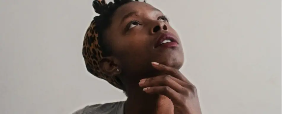 A person touching her chin and looking up.