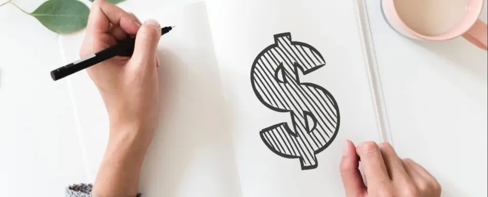 A person drawing a dollar sign on a notebook.