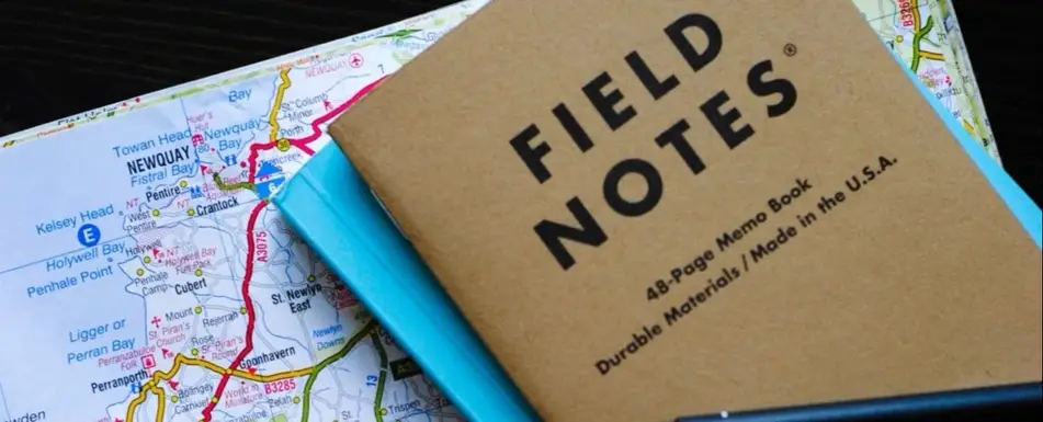 A journal that says field notes on top of a map.