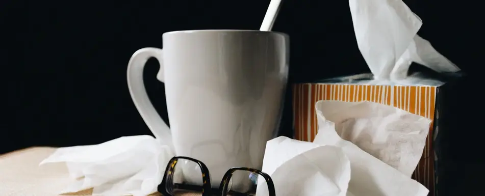 mug, tissues, and glasses on a desk