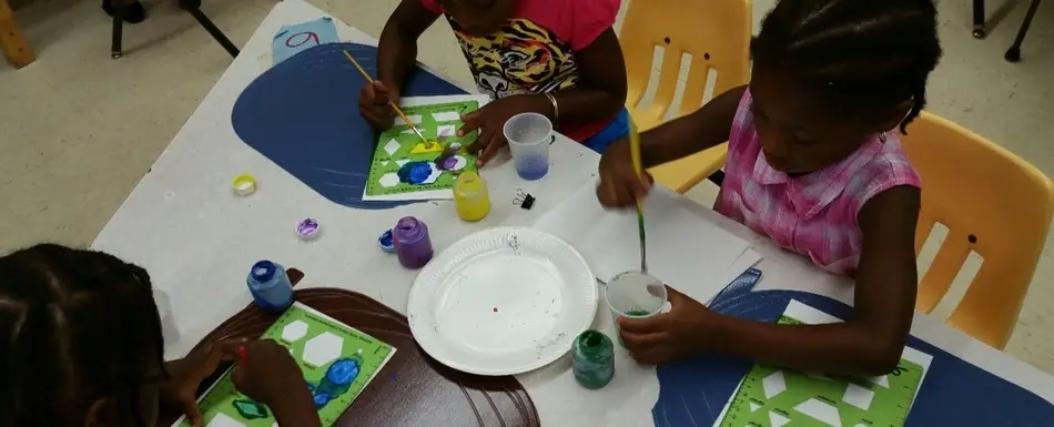 Three children painting at the Family Connection Kindercamp.