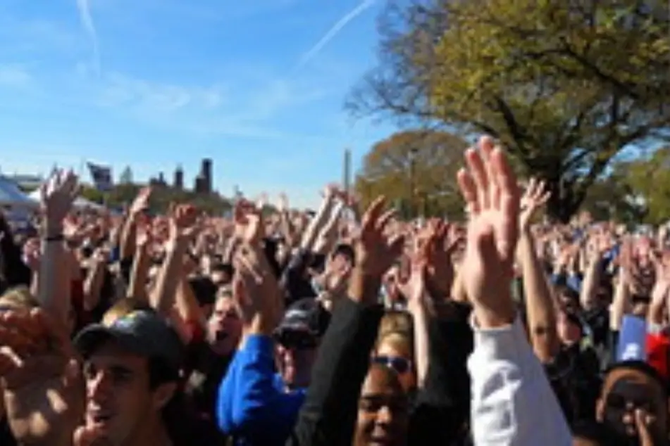 Muchísimas personas reunidas, levantando la mano