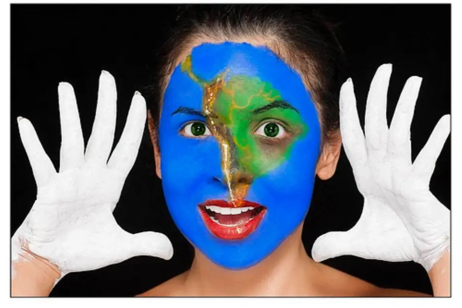 Mujer con manos pintadas de blanco y rostro pintado un mapa de Sudamérica