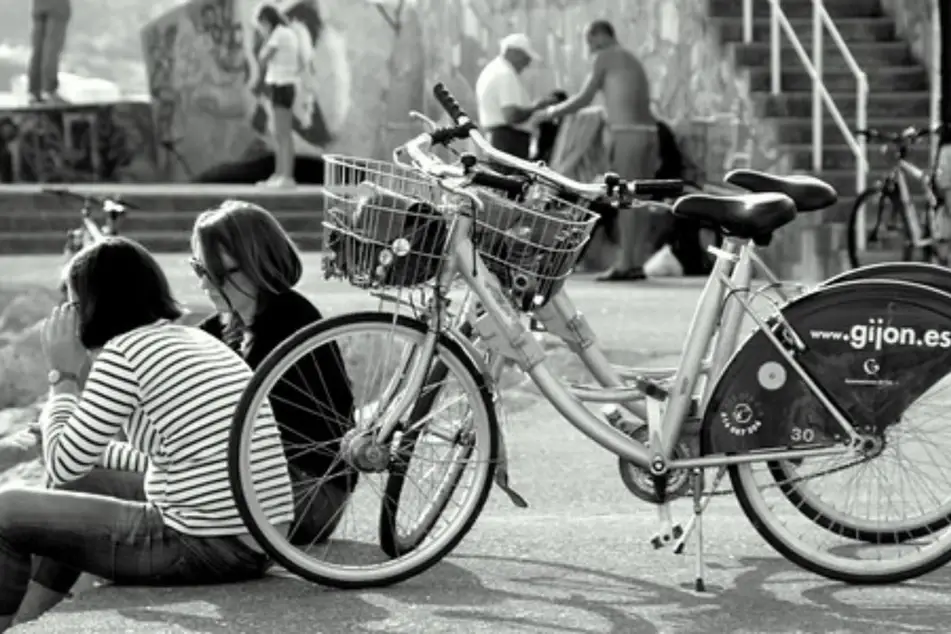 Dos mujeres sentadas junto a sus bicicletas