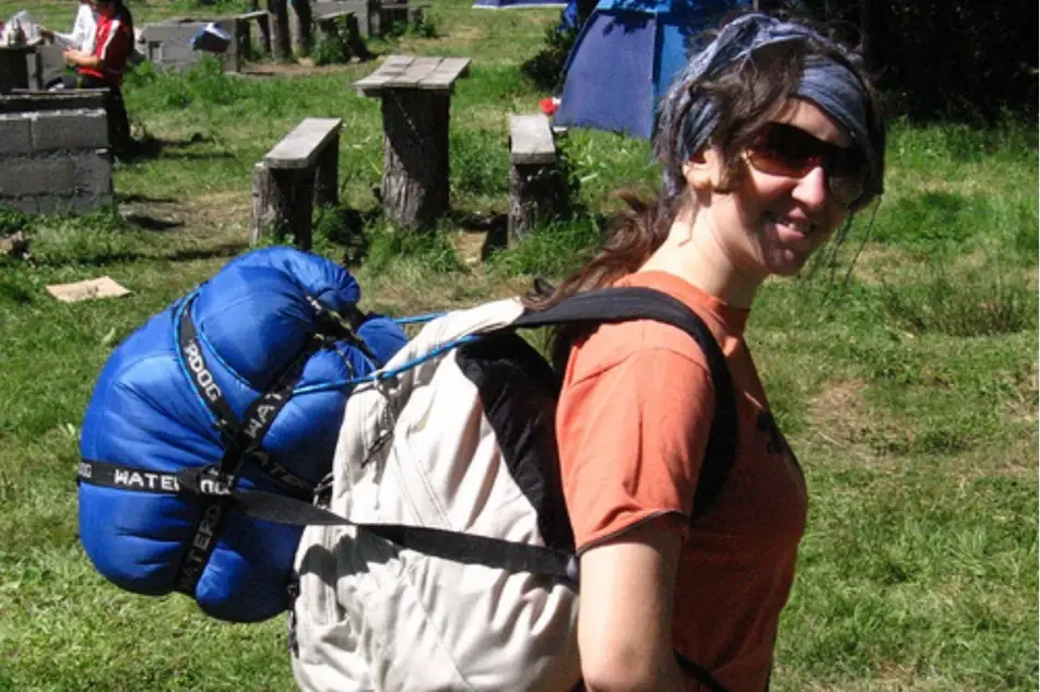 Chica con una mochila en un espacio de camping