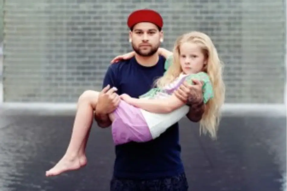 Un hombre cargando en sus brazos a una niña