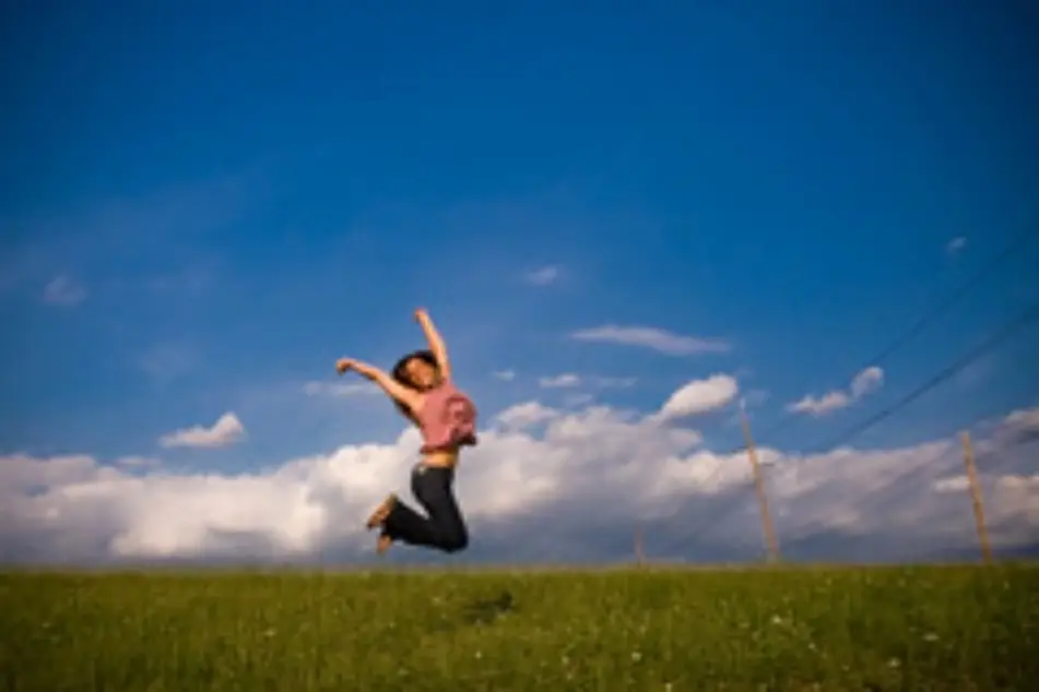Una mujer feliz saltando en el campo