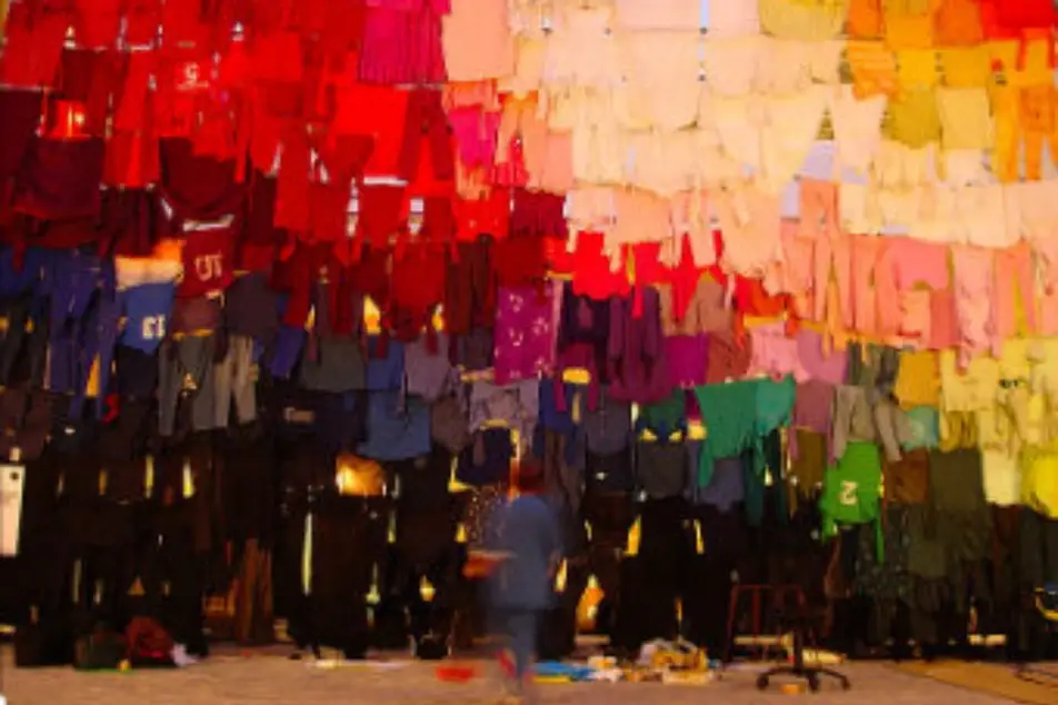Una instalación de arte en la que ven prendas de ropa de muchos colores colgadas