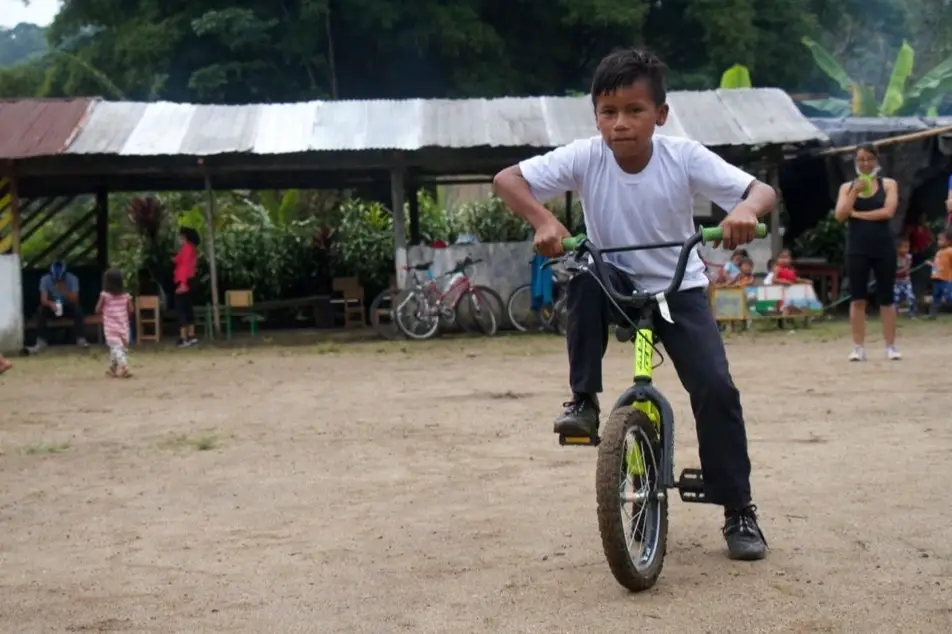 Niño de la Amazonía en Ecuador montando una bicicleta