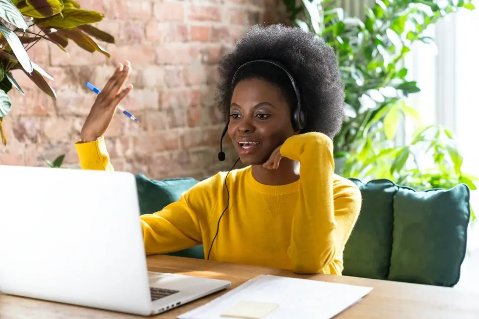 A Black woman noting employee benefits during a salary negotiation.