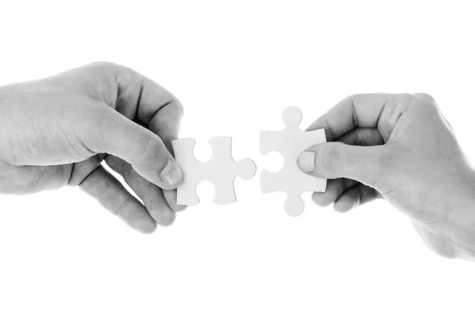 dos manos uniendo piezas del puzle